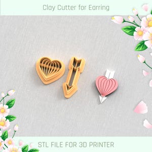 May include: Two 3D printed clay cutters for earrings. One cutter is shaped like an arrow and the other is shaped like a heart. The cutters are a light brown color. The text "Clay Cutter for Earring" and "STL FILE FOR 3D PRINTER" are visible in the image.