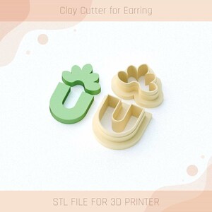 May include: A set of three clay cutters for earrings, featuring a flower, a U-shaped design, and a smaller flower with a U-shaped design. The cutters are made of a light brown plastic and are designed for use with polymer clay.