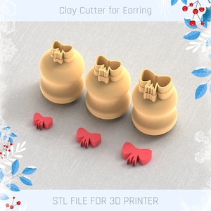 Puede incluir: Tres cortadores de arcilla impresos en 3D con forma de lazos, con un cortador de lazo más pequeño a la izquierda y un cortador de lazo más grande a la derecha. Los cortadores son de color beige y están sobre una superficie de tela beige claro.  ARCHIVO STL PARA IMPRESORA 3D.