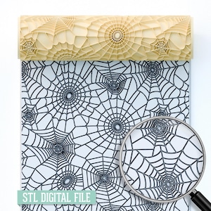 May include: A light beige rolling pin with a spiderweb pattern is positioned above a sheet of paper printed with a black spiderweb design on a white background. The text "STL DIGITAL FILE" is printed on the paper.