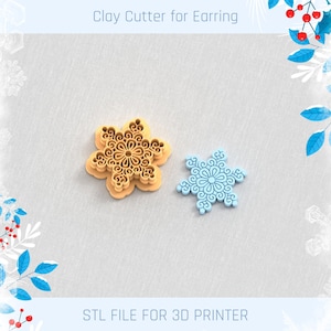 May include: Two snowflake-shaped clay cutters for earrings. One is tan, the other is light blue. The cutters have a detailed, floral design. Text at the top reads "Clay Cutter for Earring" and at the bottom "STL FILE FOR 3D PRINTER."