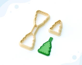 May include: A 3D printed clay cutter for earrings in the shape of a Christmas tree. The cutter is made of beige plastic and has a double-sided design. The cutter is shown next to a green Christmas tree earring.