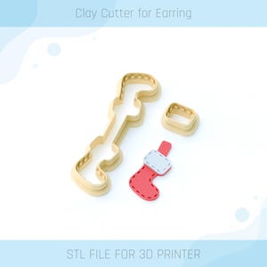Puede incluir: Un cortador de arcilla impreso en 3D para pendientes con forma de calcetín de Navidad. El cortador está hecho de plástico beige y tiene un diseño de calcetín blanco y rojo. El texto "STL FILE FOR 3D PRINTER" está en la parte inferior de la imagen.