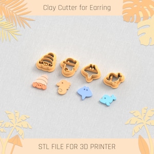 May include: A set of seven 3D printed clay cutters for earrings, featuring a variety of sea creatures. The cutters are in shades of yellow, orange, and blue. The text "STL FILE FOR 3D PRINTER" is printed below the cutters.
