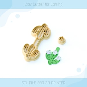 Puede incluir: Un conjunto de tres cortadores de arcilla impresos en 3D para pendientes, con un diseño de cactus con flores blancas. Los cortadores están hechos de plástico beige y están diseñados para usar con arcilla polimérica. ARCHIVO STL PARA IMPRESORA 3D.