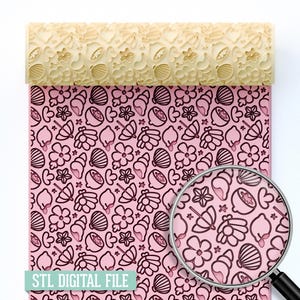 May include: A beige rolling pin with a repeating pattern of seashells, flowers, and umbrellas, resting on a pink surface with the same pattern. The text "STL DIGITAL FILE" is visible at the bottom. The design is magnified with a magnifying glass.