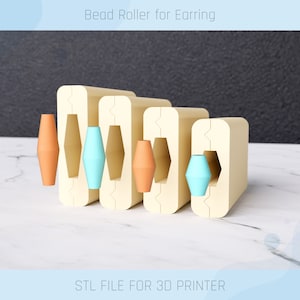 Puede incluir: Un rodillo para cuentas impreso en 3D para pendientes con cuatro moldes de diferentes tamaños. El rodillo está hecho de plástico beige y tiene un acabado liso. Los moldes están diseñados para crear cuentas redondas, ovaladas y hexagonales. El rodillo se muestra sobre una superficie de mármol blanco. STL FILE FOR 3D PRINTER