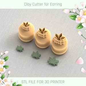 May include: Three brown clay cutters shaped like a flower with a leaf design. The cutters are on a light brown fabric surface. There are three smaller leaf-shaped cutters on the surface as well.  STL FILE FOR 3D PRINTER.