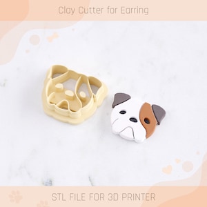 May include: A 3D printed clay cutter for earrings in the shape of a dog's face. The cutter is beige and the sample earring is white with brown accents. The text "STL FILE FOR 3D PRINTER" is at the bottom of the image.