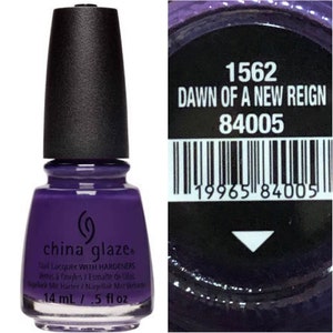 May include: A bottle of China Glaze nail polish in the shade Dawn of a New Reign, a deep purple color. The bottle is 14 ml or 0.5 fl oz. The bottle has a black cap and a silver label with the brand name and product information. The barcode is 19965 84005.