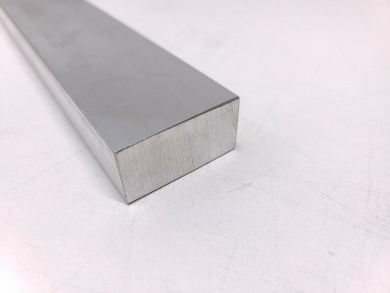 Puede incluir: Una barra rectangular de aluminio plateada con acabado cepillado.