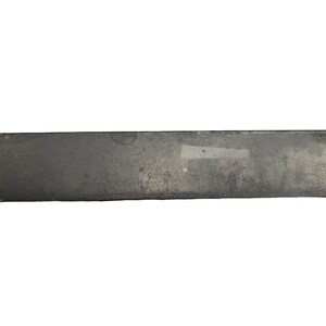May include: A long, rectangular, flat piece of metal with a dark gray color and a small yellow spot on the left side.