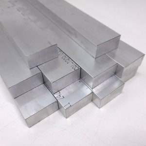 Puede incluir: Una pila de seis barras de aluminio plateadas, cada una con una secci&oacute;n transversal rectangular. Las barras est&aacute;n dispuestas en forma escalonada, con la barra superior ligeramente desplazada de las dem&aacute;s.
