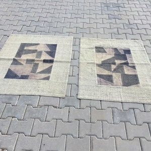 Peut inclure: Deux tapis beiges avec un motif géométrique noir et blanc. Les tapis ont une texture subtile et un design simple.