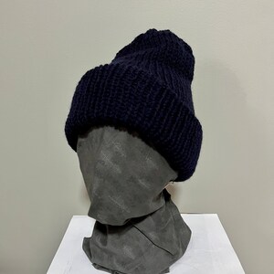 May include: A dark blue knitted beanie hat with a ribbed texture.