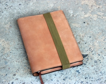 May include: A brown leather notebook with a green elastic band closure.