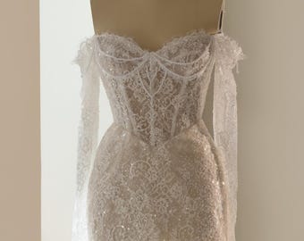 May include: A white mini dress featuring intricate lace embroidery, sequins, and pearl embellishments. The garment has a corset-style bodice, off-the-shoulder long sleeves, and a high lace choker neckline with a scalloped edge finish.
