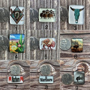 Puede incluir: Una colección de cabujones de vidrio rectangulares con varios diseños. Los diseños incluyen una calavera de toro con detalles turquesa, una manada de bisontes, un paisaje desértico con cactus y el logotipo de Marlboro.