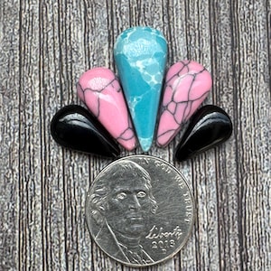 May include: A collection of teardrop-shaped beads in various colors: turquoise, pink, and black. The turquoise bead has a white veining pattern, while the pink beads have a black crackle effect. A US nickel coin is included for size reference.