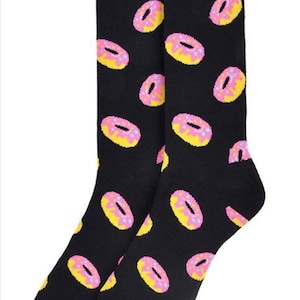 May include: A pair of black socks with a donut pattern. The donuts are pink with yellow frosting and sprinkles.