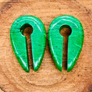 Può includere: Un paio di dilatatori per orecchie a forma di lacrima in malachite verde con un design a buco della serratura.