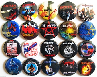 May include: A collection of twenty-one round metal pinback buttons featuring various heavy metal band logos and album art. The buttons display a variety of colors, including black, red, blue, and yellow, with text such as "Exciter," "Helstar," and "Onslaught."