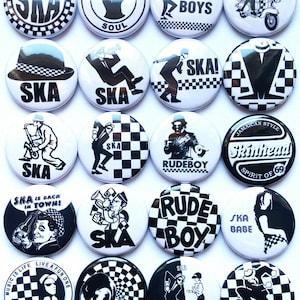 Op de afbeelding: Een set van 16 ronde zwart-witte knoppen met verschillende ska-muziekdesigns. De knoppen bevatten afbeeldingen van muzikanten, geruite patronen en tekst zoals "SKA", "Rude Boys", "Skinhead" en "Jamaican Style".