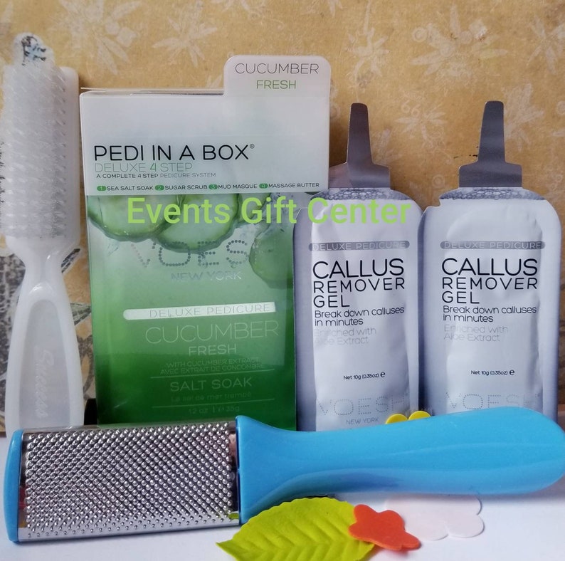 May include: A set of cucumber-scented foot care products in a white box with a green and white design. The set includes a foot scrub, a foot mask, a foot cream, and a foot file. The products are labeled "Pedi in a Box" and "Cucumber Fresh".