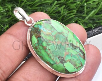 May include: A silver pendant with a green and brown oval turquoise stone.