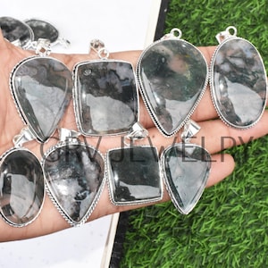 May include: A collection of eight silver pendant charms featuring green and gray agate stones. The stones are all different shapes and sizes, and they are set in silver.