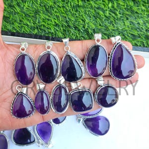 Può includere: Una collezione di ciondoli in ametista con montature in argento. I ciondoli sono di varie forme, tra cui a goccia, ovale e quadrata.