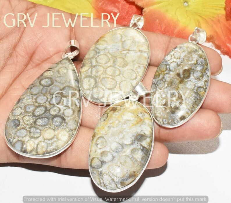 Puede incluir: Cuatro colgantes de plata con coral fosilizado en tonos grises, blancos y marrones. El coral tiene un patr&oacute;n circular.
