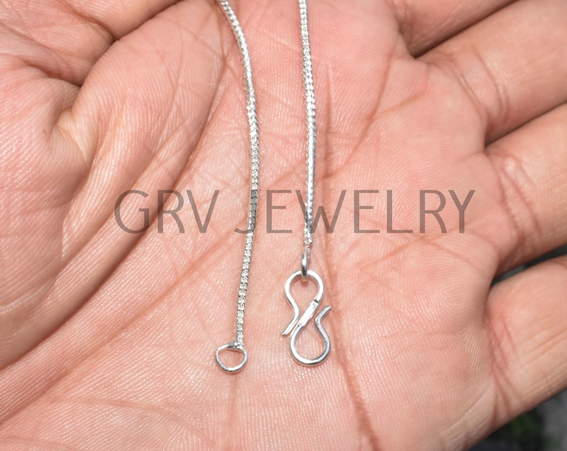 Puede incluir: Un collar de cadena de plata con un cierre de langosta y un cierre de figura ocho. La cadena est&aacute; hecha de peque&ntilde;os eslabones redondos.