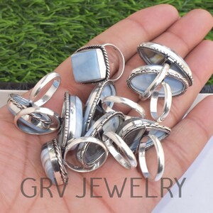 May include: A collection of silver rings with blue opal stones. The rings are in various shapes and sizes, and some have intricate designs.