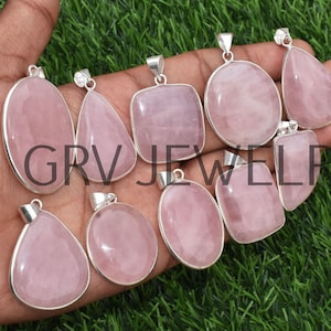 May include: Assortment of nine pink rose quartz pendants with silver settings. The pendants are various shapes, including oval, teardrop, and square.
