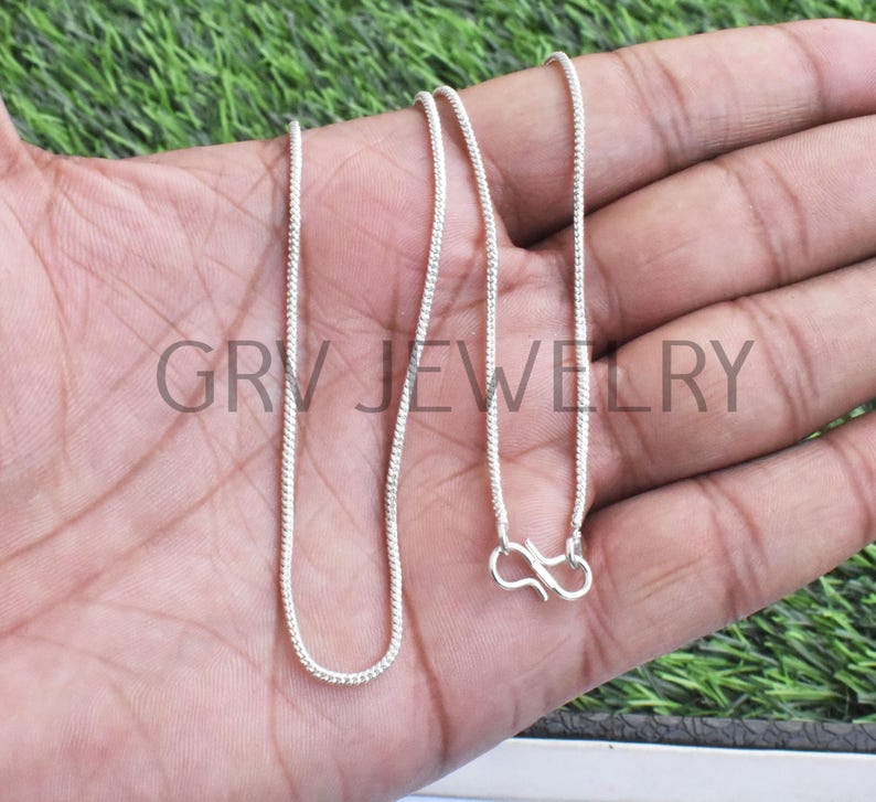 Puede incluir: Un collar de cadena de plata con cierre de langosta. La cadena es fina y tiene un dise&ntilde;o delicado, ligeramente texturizado.