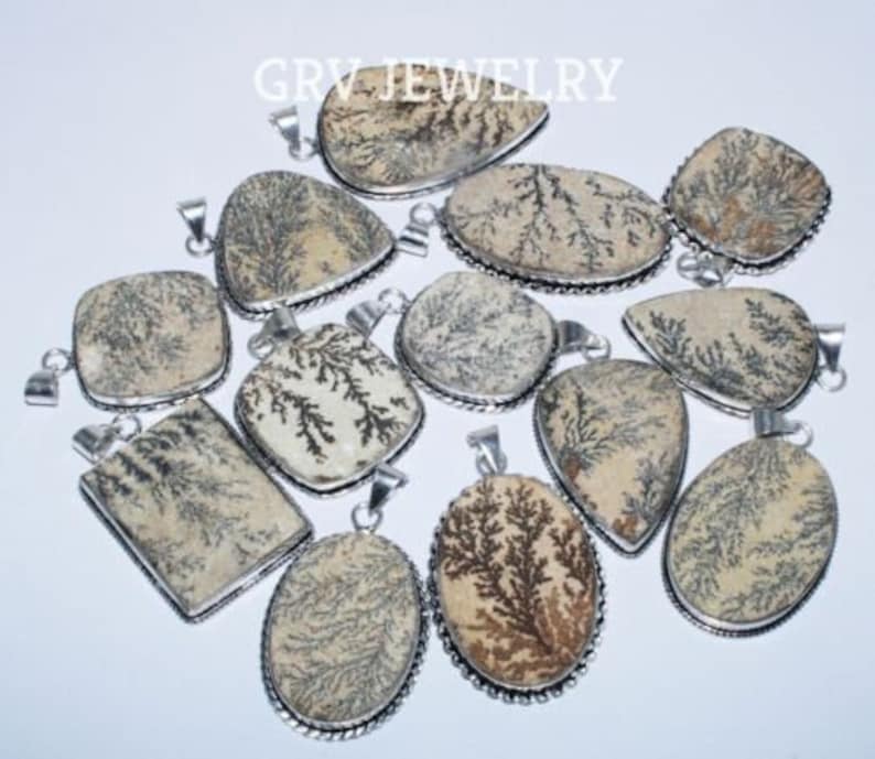 Puede incluir: Una colecci&oacute;n de 12 colgantes de plata con piedras de &aacute;gata dendr&iacute;tica. Las piedras son de color beige claro con patrones dendr&iacute;ticos marrones. Los colgantes son de diferentes formas y tama&ntilde;os.