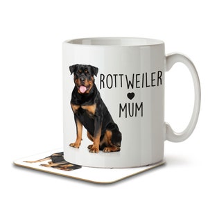 Op de afbeelding: Witte keramische mok met een afbeelding van een zwarte Rottweiler-hond en de tekst "Rottweiler Mum" met een zwart hart.