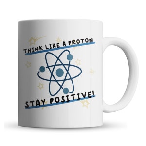 May include: White ceramic coffee mug with a black and blue atom illustration and the text "Think like a proton, stay positive!" in black text.