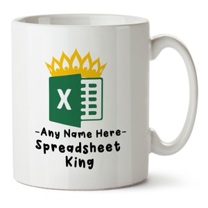 May include: White ceramic mug featuring a green and yellow graphic of the Microsoft Excel logo with a gold crown on top. The text "Any Name Here - Spreadsheet King" is printed below the logo.