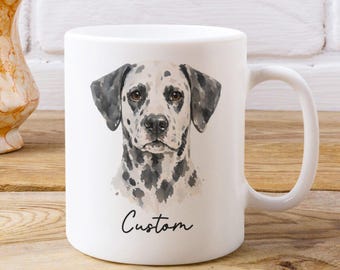 Op de afbeelding: Een witte keramische mok met een aquarelillustratie van een dalmatiër op de voorzijde. Onder de kop van de hond staat het woord Custom in een zwart cursief lettertype gedrukt. De mok heeft een standaard handvat en een gladde afwerking.
