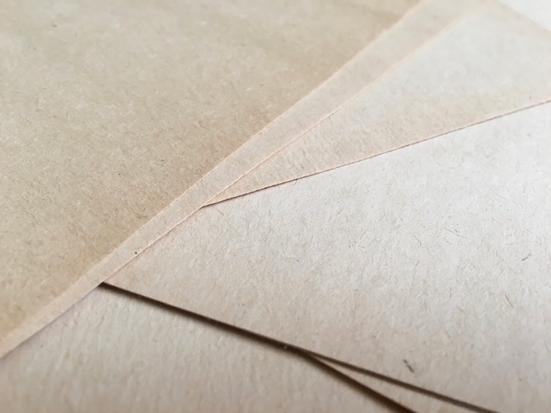 May include: Close-up of several sheets of light brown craft paper stacked on top of each other.
