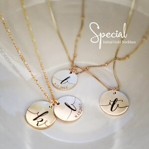 May include: Three gold necklaces with circular pendants featuring handwritten initials and the date 9.12.2012. The necklaces are on a white surface.  Special Initial Gold Necklace.