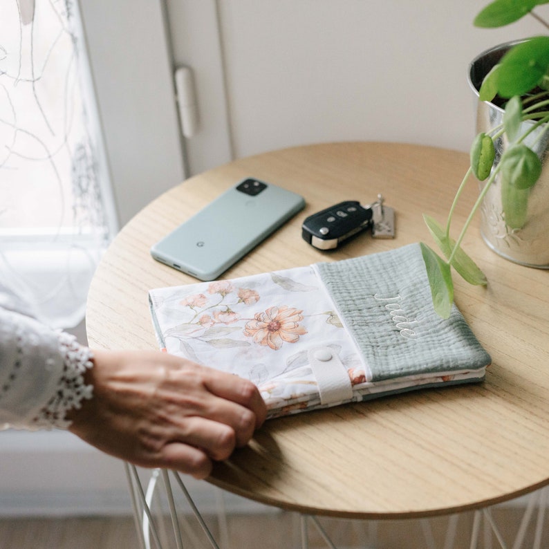 Maman qui prendre le carnet de santé posé à côté des clefs de voiture et du téléphone avant de partir chez le docteur.