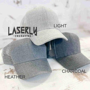 Puede incluir: Tres gorras de b&eacute;isbol grises con paneles traseros de malla. Las gorras est&aacute;n etiquetadas como "Heather", "Light" y "Charcoal".