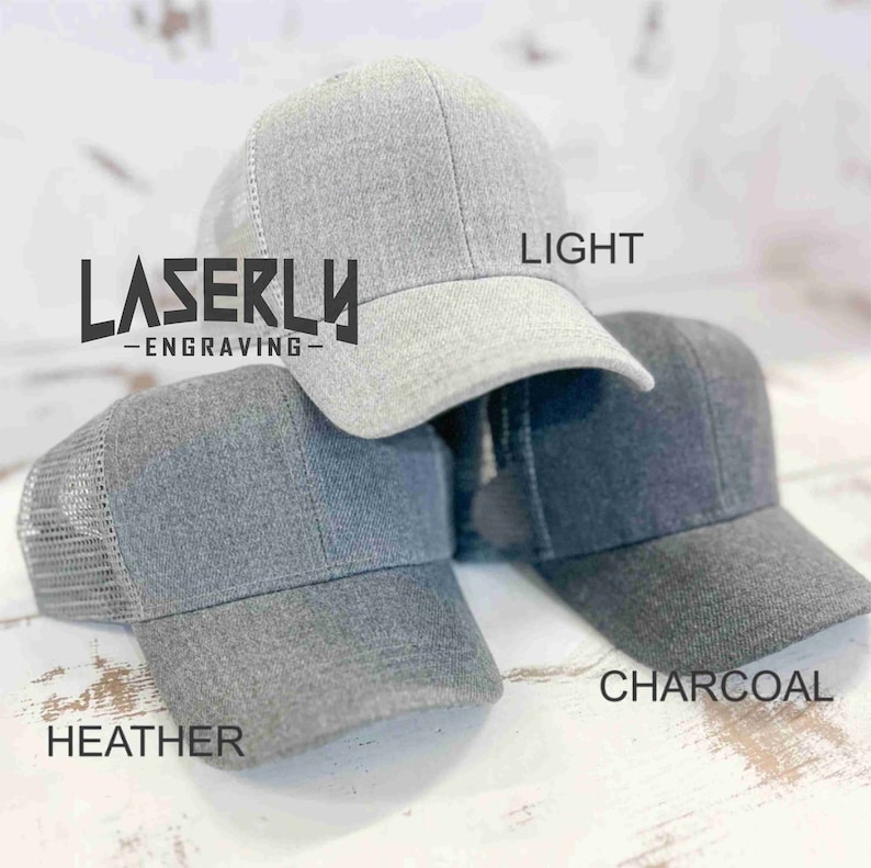 Puede incluir: Tres gorras de b&eacute;isbol grises con paneles traseros de malla. Las gorras est&aacute;n etiquetadas como "Heather", "Light" y "Charcoal".