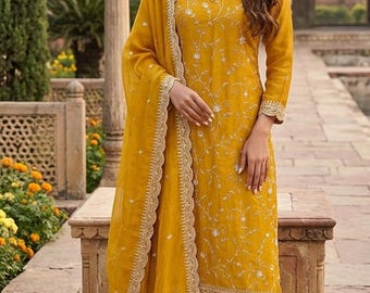May include: Mustard yellow salwar kameez suit with detailed embroidery and gold edging. The long-sleeved tunic and trousers are complemented by a sheer dupatta. The outfit features delicate floral patterns, suitable for special occasions.