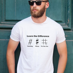 Puede incluir: Una camiseta blanca con el texto "Learn the Difference" y tres símbolos: un hashtag, un símbolo de sostenido y un tablero de tres en raya. Los símbolos están etiquetados como "Hashtag", "Sharp" y "Tic-Tac-Toe".