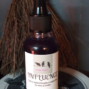 May include: A dark glass bottle with a black dropper top, filled with a purple liquid. The label reads "INFLUENCE" with the text "Used to implant thoughts or actions into the mind of another." The label also features three raven silhouettes.