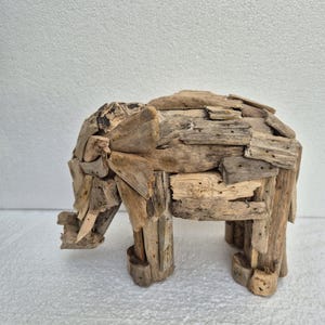 Pu&ograve; includere: Una scultura di elefante in legno fatta a mano. L'elefante &egrave; costruito con piccoli pezzi di legno di deriva, mostrando un aspetto naturale e invecchiato. La scultura ha quattro robuste zampe e una proboscide dettagliata, ideale per l'arredamento della casa.